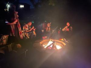 um grupo de pessoas sentadas à volta de uma fogueira em Riverfront Getaway on the Wild and Scenic em Sedro-Woolley