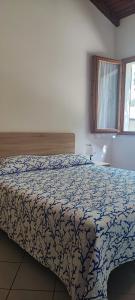 a bedroom with a bed with a blue and white comforter at Camping Ancora in Comacchio
