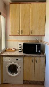 a kitchen with a washing machine and a microwave at Puerto Barrio Alto in El Puerto de Santa María