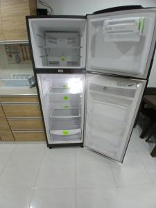 an empty refrigerator with its door open in a kitchen at posada kyca cerca ala playa in Buenavista