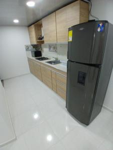 uma cozinha com um frigorífico de aço inoxidável num quarto em cerca al mar 1 em Buenavista