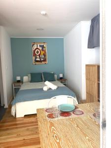 a bedroom with a bed with blue walls and a table at Terrace House in Lisbon