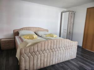 a bedroom with a large bed with a tufted headboard at Ferienwohnung Flonta in Mittweida