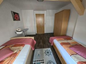 1 dormitorio con 2 camas y suelo de madera en Ferienwohnung Flonta, en Mittweida