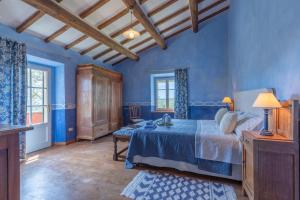 um quarto com paredes azuis, uma cama e uma mesa em casale vergheria em Magliano in Toscana