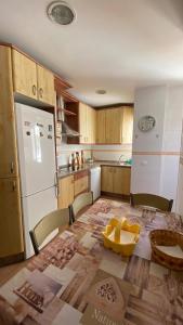 a kitchen with a table and a white refrigerator at Puerto Barrio Alto in El Puerto de Santa María