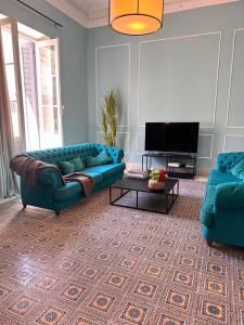 a living room with a blue couch and a tv at Appartement rénové en plein centre historique in Tunis