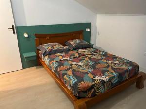 a bed with a colorful comforter in a bedroom at GITE PEI LA VANILLE "Studio Duplex TI Kaz" in Sainte-Suzanne