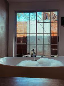 a bath tub in a room with a large window at La Maracuya Panama in Playa Coronado