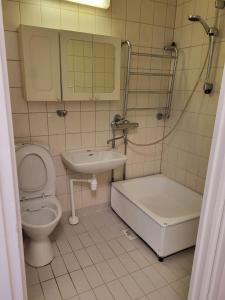 uma casa de banho com um WC, um lavatório e uma banheira em Convenient Stay Helsinki em Helsinque