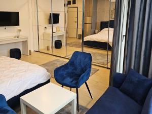 a bedroom with a bed and a chair and mirror at Mamaia Nord - Studio in Mamaia