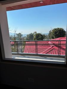 a view from a window of a stadium with red seats at Amoha Homes in Bīr +7 photos