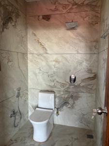 a bathroom with a white toilet in a shower at Amoha Homes in Bīr