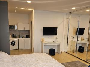 a bedroom with a bed and a tv on a wall at Mamaia Nord - Studio in Mamaia