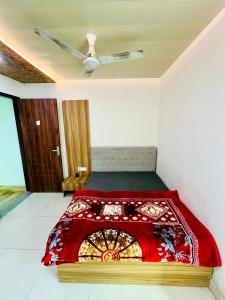 a bedroom with a bed with a red blanket at Shri Hari Cottage in Mathura