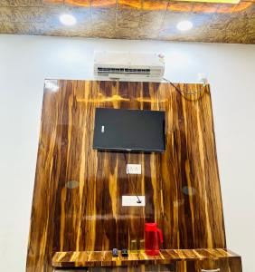 a room with a tv on top of a wooden wall at Shri Hari Cottage in Mathura