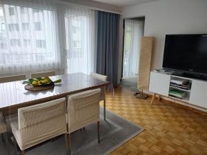 een woonkamer met een tafel met stoelen en een televisie bij Panorama in Escholzmatt