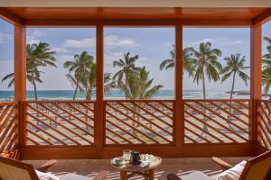 a room with a view of the ocean and palm trees at The Club by Fanar in Salalah