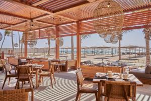 un restaurante con mesas y sillas y vistas a la playa en The Club by Fanar en Salalah