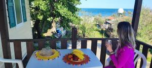 a woman sitting at a table with a plate of fruit at Camping Ancora in Comacchio