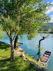 un barco sentado en el césped junto a dos árboles en Una Rose, en Bihać