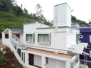 a white house with a staircase on the side of it at Casa de Selas in Coonoor