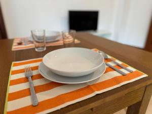 una mesa con una placa y un tenedor y un cuchillo en Fantástico apartamento cerca de Santander en El Astillero