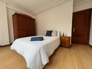 sypialnia z białym łóżkiem z niebieską poduszką w obiekcie Fantástico apartamento cerca de Santander w mieście El Astillero