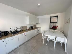 a kitchen with a white table and white cabinets at En-suite Double Room in Cork in Cork