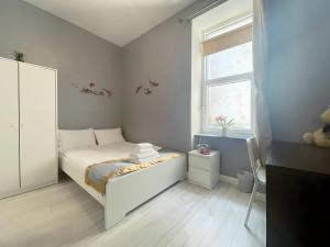 um pequeno quarto com uma cama e uma janela em Leitrim Property Cork em Cork