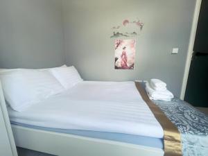 Bett mit weißer Bettwäsche und Kissen in einem Zimmer in der Unterkunft En-suite Double Room in Cork in Cork