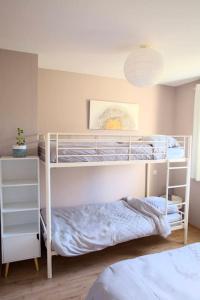 ein Schlafzimmer mit zwei Etagenbetten in einem Zimmer in der Unterkunft Maison calme avec jardin proche de Toulouse in Odars