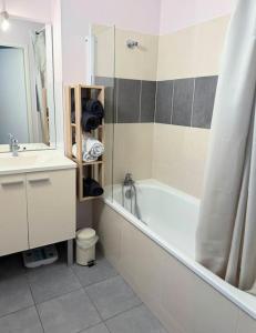 ein Badezimmer mit Badewanne, Waschbecken und Spiegel in der Unterkunft Maison calme avec jardin proche de Toulouse in Odars + 20 Fotos