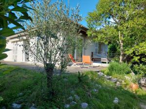 une maison avec deux chaises orange dans la cour dans l'établissement Villa entière avec jardin, à Aix-les-Bains