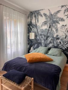 - une chambre avec un lit orné d'une fresque murale de palmiers dans l'établissement Le petit toulousain chic, à Toulouse