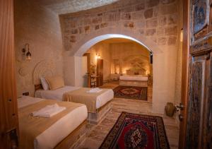 a bedroom with two beds and an arched doorway at Sur Cave Hotel in Ürgüp