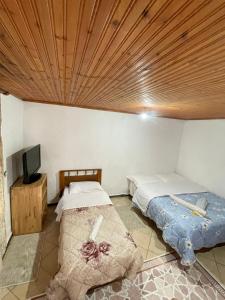 Duas camas num quarto com tecto em madeira em GuestHouse Lokthi em Theth
