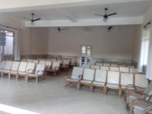 an empty waiting room with white chairs and windows at Hospedagem Sul de Minas Caxambu in Caxambu