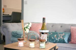 a table with a bottle of wine and flowers on a couch at The Luxury Dartmoor Den, Dartmoor, Devon in Ashburton