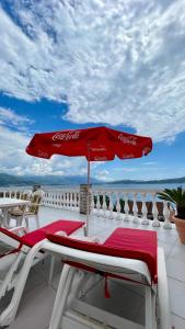 un paraguas de cocacola sentado en la parte superior de un balcón en Family House with pool & sea view, en Bijela