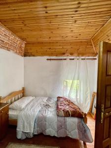 um quarto com uma cama e um tecto em madeira em GuestHouse Lokthi em Theth