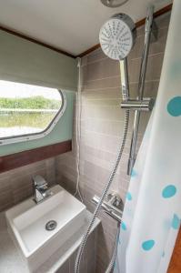 a bathroom with a sink and a shower at Dutch Cruiser Ship on a Tranquil Secluded River in Tonbridge