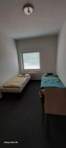 two beds in a room with a window at TJ Baník Ostrava in Ostrava