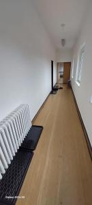 Habitación vacía con 2 radiadores blancos y suelo de madera. en TJ Baník Ostrava, en Ostrava