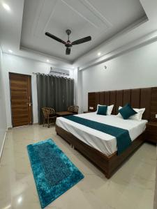a bedroom with a large bed with a blue rug at Hotel Yog Vriksh in Rishīkesh
