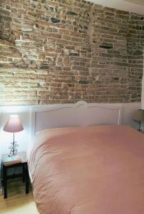 Un dormitorio con una pared de ladrillo y una cama en Casina Centotrecento-Romantic & Quite Apartment- en Bolonia