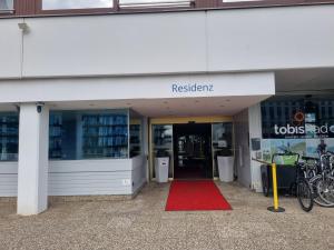 un bâtiment doté d'un tapis rouge devant un magasin dans l'établissement Gut-zu-Mir FeWo Maritim Travemünde, à Travemünde
