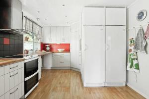 La cuisine est équipée de placards blancs et d'un réfrigérateur blanc. dans l'établissement Hagavägen 5, à Grebbestad