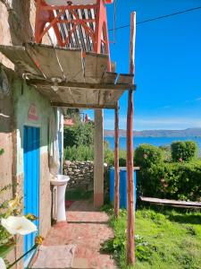 a building with a porch with a view of the ocean at Arco Wasi Hospedaje Amantani in Puno