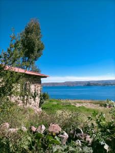 an old stone building on the shore of a lake at Arco Wasi Hospedaje Amantani in Puno